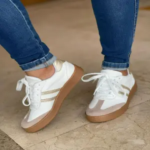 Tenis blancos linea dora suela baja cafe